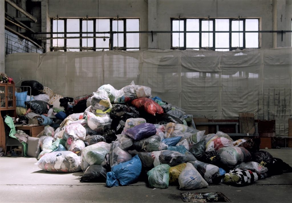 Garbage bags full of clothes in a warehouse.