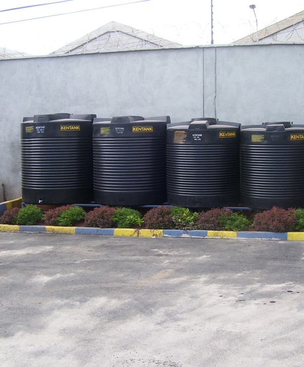 Four small black rainwater retention tanks.