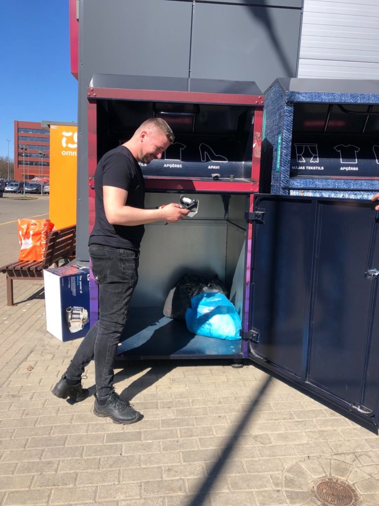 A technician deploying smart sensor into the textile waste container. 