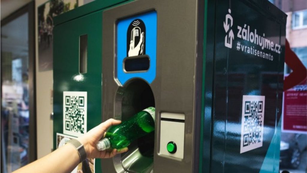 Someone is putting a plastic bottle in the reverse vending machine at the supermarket in the Czech republic.