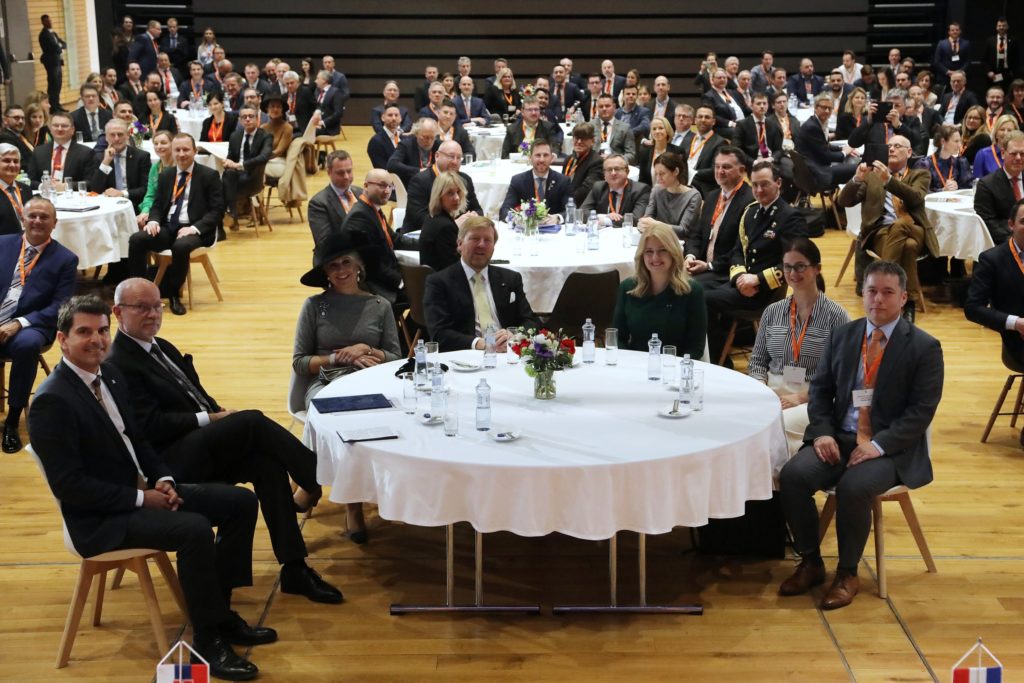 Behind the table sitting the Dutch Royal couple, the president of Slovak republic and Andrea Basilova, co-founder of Sensoneo at business forum. Behind other tables other representatives of the states are sitting. 