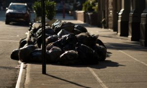Black bags of waste on a pile in the street in New York.