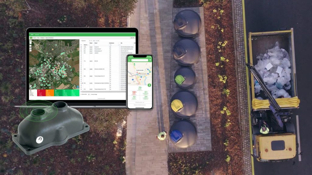 A garbage truck with a hydraulic arm collects waste from semi-underground bins in the garbage area. Sensoneo sensor with our Smart Waste Management Software System and mobile app.
