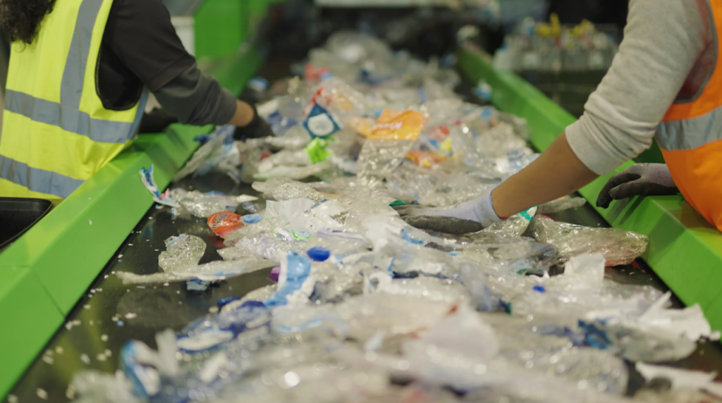 People are sorting used plastic bottles and cans in the recycling facility in Malta.