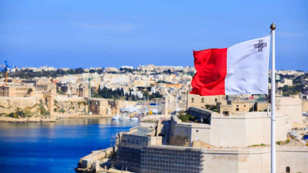 Malta flag with the historical city in the background.