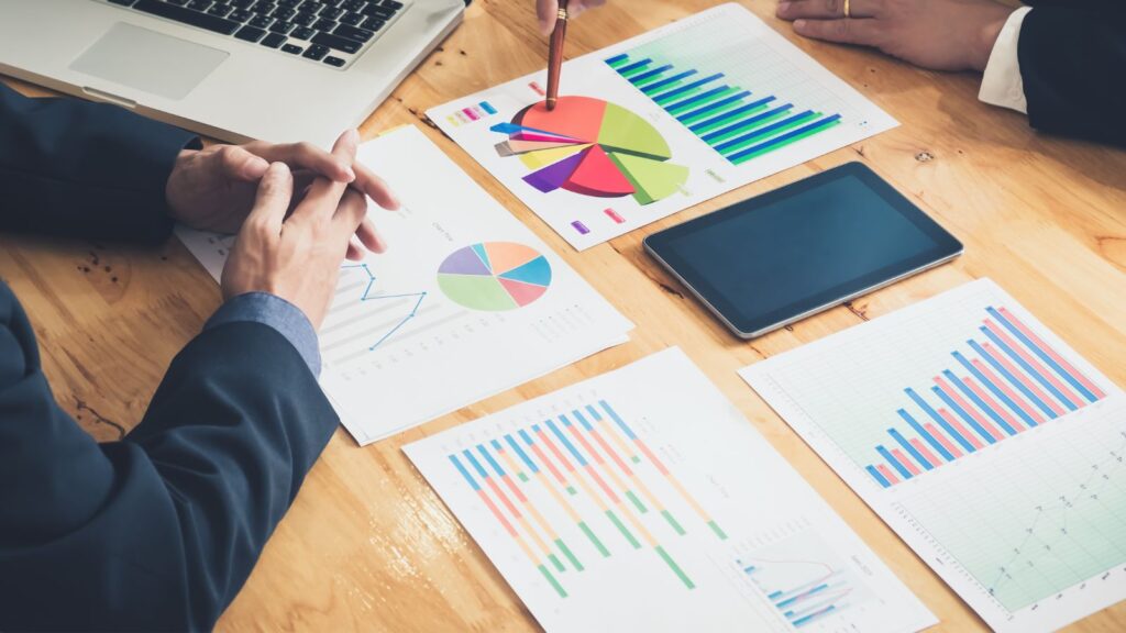 Reports and data on the sheets placed on the table among two different stakeholders.