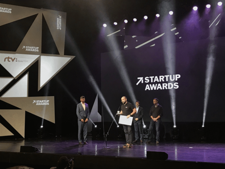 A Startup Awards ceremony where an individual is giving a speech on stage, holding an award.