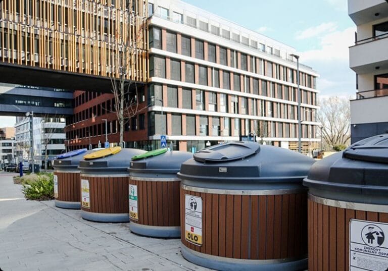 Modern waste bins with colored lids for recycling in an urban environment.