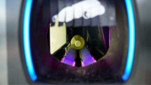 A plastic bottle inside a recycling machine, about to be processed.
