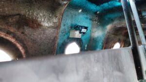  Interior of a container with a sensor mounted on the wall, used for monitoring waste levels or conditions inside the container.