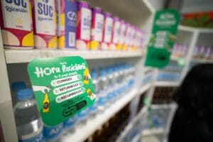 A store shelf display promoting Romania’s deposit-return system with colorful cans and signage.