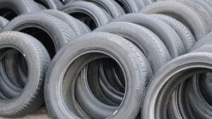 Rows of stacked, unused rubber tires arranged in an outdoor area.