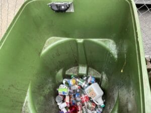 A recycling bin with a fill-level sensor shows only a small amount of waste inside.