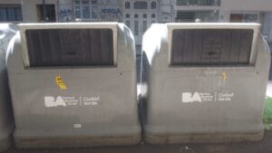 Two large grey public waste containers on a sidewalk as a part of a municipal waste-management.