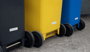 Colour-coded waste bins with tracking labels support organized collection in a take-back system.