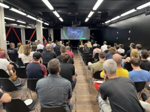 Audience attending a presentation in a conference room.