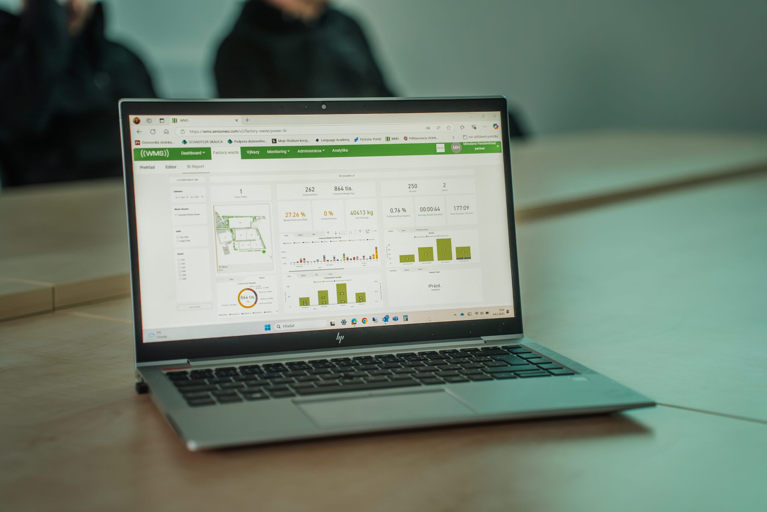 Laptop displaying a waste-management analytics dashboard with charts, metrics, and site overview map.