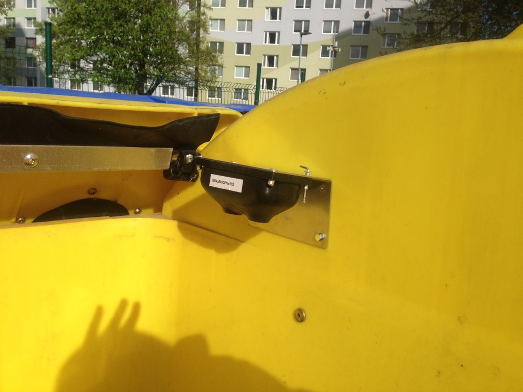 Yellow plastic garbage container with installed smart sensor.